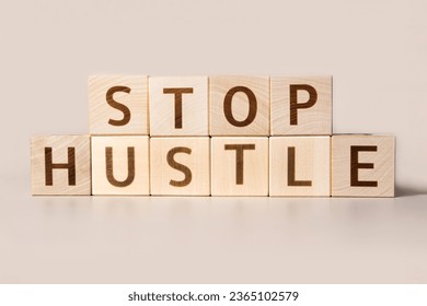 The word STOP HUSTLE on cubes on a beige studio background. Copy Space. Written. Text words matter. Conceptual Image. Concept of maintaining mental health while working overtime. Don't work long hours - Shutterstock ID 2365102579