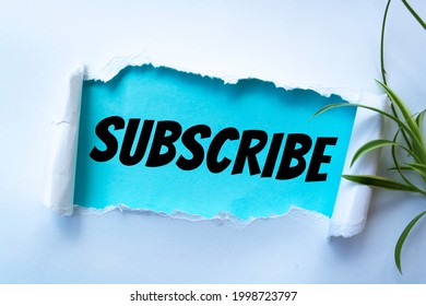 The word subscribe appearing behind torn paper - Shutterstock ID 1998723797