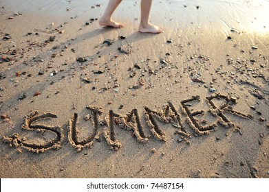 the word summer written in sand