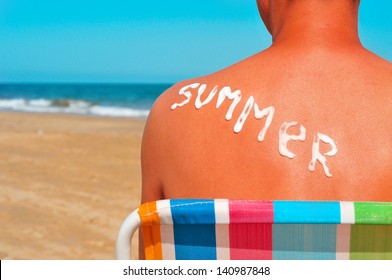 The Word Summer Written With Sunblock On The Sunburnt Back Of A Man Who Is Sunbathing On The Beach