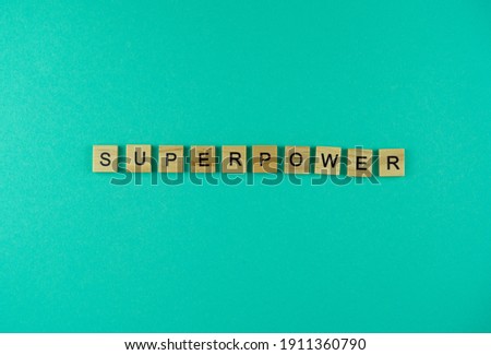 Word Superpower. The phrase is laid out in wooden letters. Top view. Motivation. Blue background. Copy space.