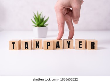 the word taxpayer wooden cubes with burnt letters, debts, gray background top view. - Shutterstock ID 1863652822