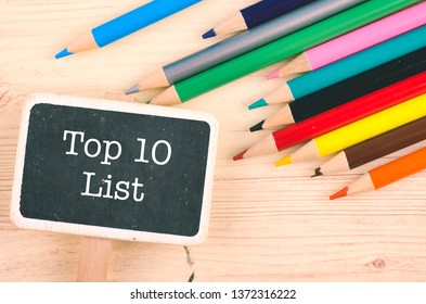 word TOP 10 LIST written on wooden signage over colorful pencil on desk