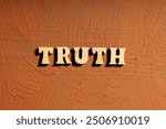 The word "truth" is written in wooden letters on a brown wall. The letters are laid out on a wooden bar, which gives the word a unique artistic appearance. The concept of authenticity and sincerity