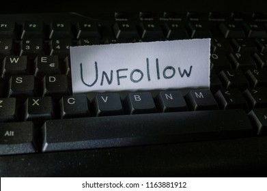 word unfollow written on a piece of white paper and placed on black computer keyboard. Concept technology tech words, digital vocabulary, terms used on the internet