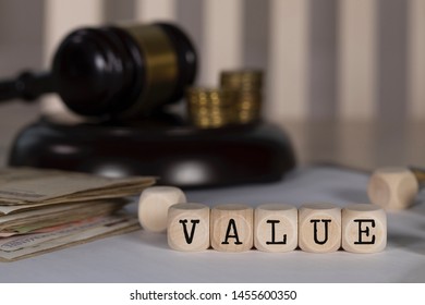 Word VALUE composed of wooden dices. Auction gavel on the table in the background. Closeup - Shutterstock ID 1455600350