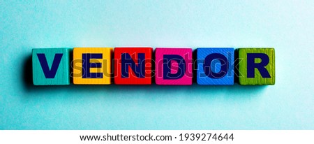 The word VENDOR is written on multicolored bright wooden cubes on a light blue background