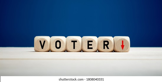 The Word Voter With Downward Arrow On Wooden Cubes. Elections And Decreasing Voter Turnout Concept.