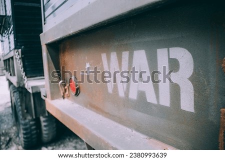 the word "War" in graffiti style, artfully obscured and partially faded on a textured urban wall. The blurred effect adds mystery and intrigue