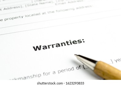 Word warranties with wooden pen close up - Shutterstock ID 1623293833