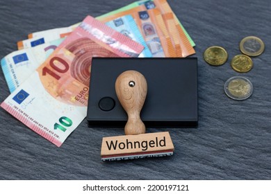 The Word Wohngeld On A Stamp With Euro Banknotes.
Wohngeld Means Housing Benefit.