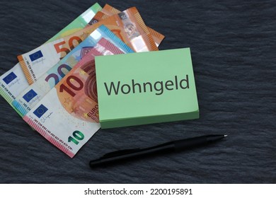 The Word Wohngeld Written On A Legal Pad With Euro Banknotes.
Wohngeld Means Housing Benefit.