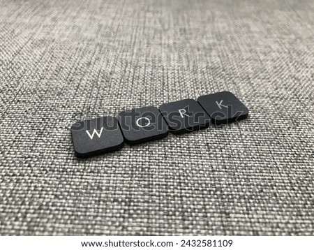 The word work written in black plastic letters on a gray background.