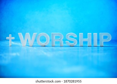 Word Worship made with cement letters on blue marble background. Copy space. Biblical, spiritual or christian reminder. Good friday, Easter day in church. Christian music concert, Sunday service.