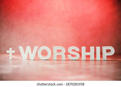 Word Worship made with cement letters on red marble background. Copy space. Biblical, spiritual or christian reminder. Good friday, Easter day in church. Christian music concert, Sunday service.