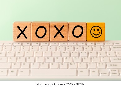 The Word XOXO And A Smiley Face. Greeting Used On The Internet, E.g. In Correspondence Between Friends. The Inscription On Wooden Blocks Against The Background Of A Computer Keyboard