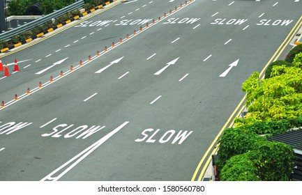 Worded Marking SLOW Painted On The Road Every Lanes To Warn Drivers To Slow Down Before Pass The Toll Gates