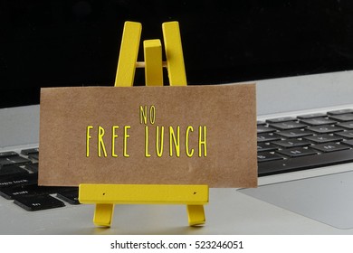 Wording No Free Lunch On Mini Stand With The Laptop Background. Greeting And Business Concept.