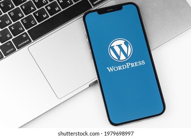 WordPress logo mobile app on screen smartphone, iPhone with notebook, workplace background. WordPress - open source site content management system. Moscow, Russia - April 14, 2021