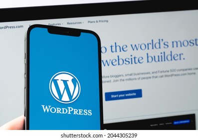 WordPress logo mobile app on screen smartphone iPhone with Macbook display closeup. WordPress - open source site content management system. Moscow, Russia - June 22, 2021