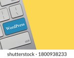 WORDPRESS text on keyboard over yellow background. Business and technology concept