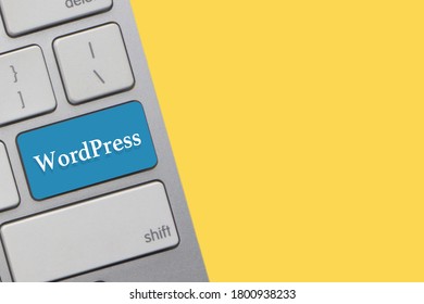WORDPRESS text on keyboard over yellow background. Business and technology concept