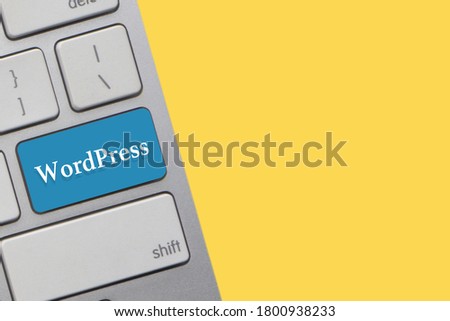 WORDPRESS text on keyboard over yellow background. Business and technology concept