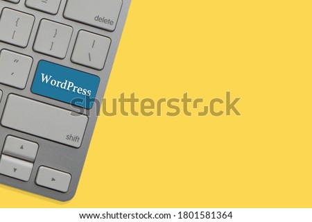 WORDPRESS text on keyboard over yellow background. Business and technology concept
