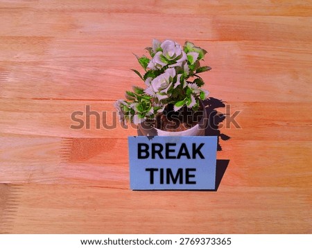 The words break time on a note attached to a beautiful artificial flower tree