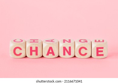 Words chance and change written with wood cubes on pink background - Concept of woman, chance and empowerment