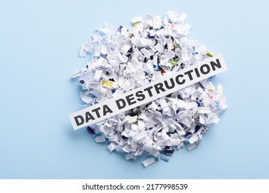 Words Data Destruction On Top Of Heap Of Cross Shredded Paper On Blue Background Top View