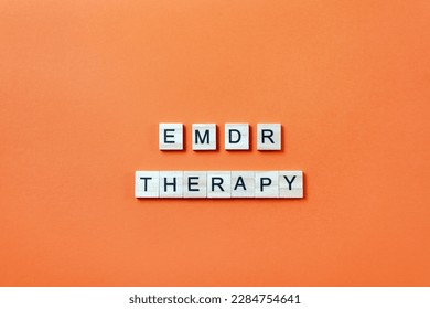 Words EMDR therapy from wooden blocks with letters on orange background. Minimal concept of Eye Movement Desensitization and Reprocessing. Method of psychotherapy working with traumatic memories - Shutterstock ID 2284754641
