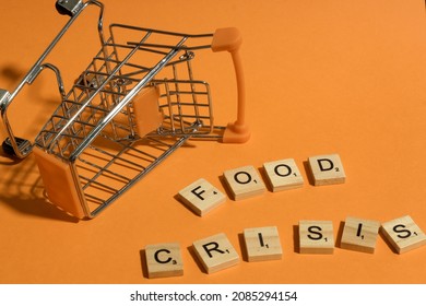 Words FOOD CRISIS Written With Scrabble Letters Next To Empty Supermarket Shopping Cart Illustrating Food Shortage Caused By Corona Virus Outbreak, Covid-19 Pandemic. Editorial Photo.