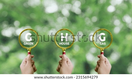 Words 'GHG, greenhouse gas' on magnifier glass. Business and GHG greenhouse gas concept.