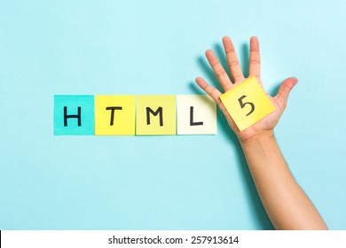 The words HTML5 on blue background and hand showing the 5 number. HTML5 is a language of the Internet.