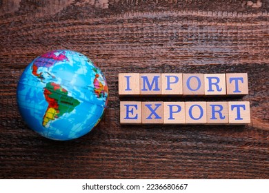Words Import and Export made of cubes and globe on wooden table, flat lay