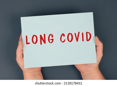 The Words Long Covid Are Standing On A Paper, Hands Hold The Message, Problems After Covid-19 Disease