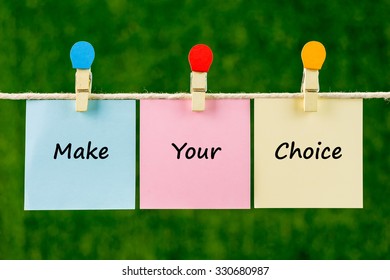 Words Of Make Your Choice On Sticky Color Papers Hanging By A Rope Against Blurred Green Background.