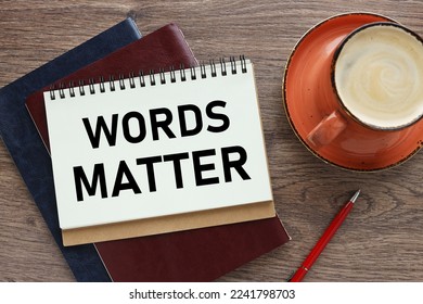 WORDS MATTER. open notepad with text near orange mug - Shutterstock ID 2241798703