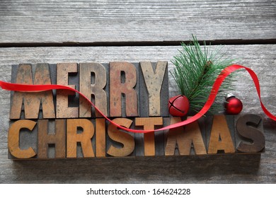 The Words Merry Christmas With Red Ribbon On An Old Wood Surface