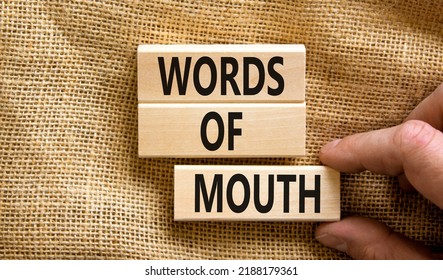 Words of mouth symbol. Concept words Words of mouth on wooden blocks on a beautiful canvas table canvas background. Businessman hand. Business, finacial and words of mouth concept. Copy space.