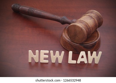 Words NEW LAW And Judge Gavel On Table. New Laws Comming And Legal Reform Concept.