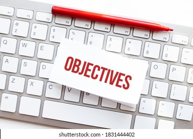 Words OBJECTIVES written on torn paper on a computer keyboard
