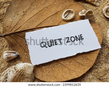 The words quiet zone on the beach sand background.