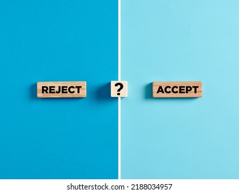 The words reject and accept on wooden blocks with question mark symbol. Dilemma or choice between to approve or to refuse an application concept.