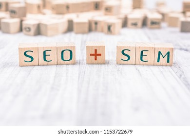 The Words SEO And SEM Formed By Wooden Blocks On A White Table