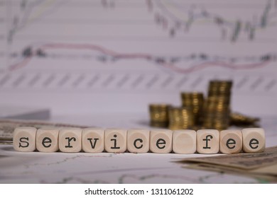 Words SERVICE FEE Composed Of Wooden Letter. Stacks Of Coins In The Background. Closeup