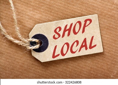 The Words Shop Local In Red Text On A Brown Paper Price Label Or Luggage Tag With String And Wrapping Paper