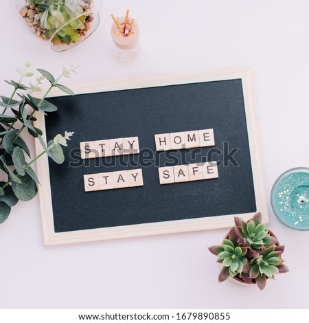 Words stay home, stay safe made of wooden blocks, concept of self quarantine at home as preventative measure against virus outbreak. Flat lay with inspiration quote, staying at home during pandemic