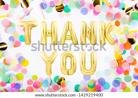 Words THANK YOU made of golden inflatable balloon letters in a frame made of colorful confetti on white background
